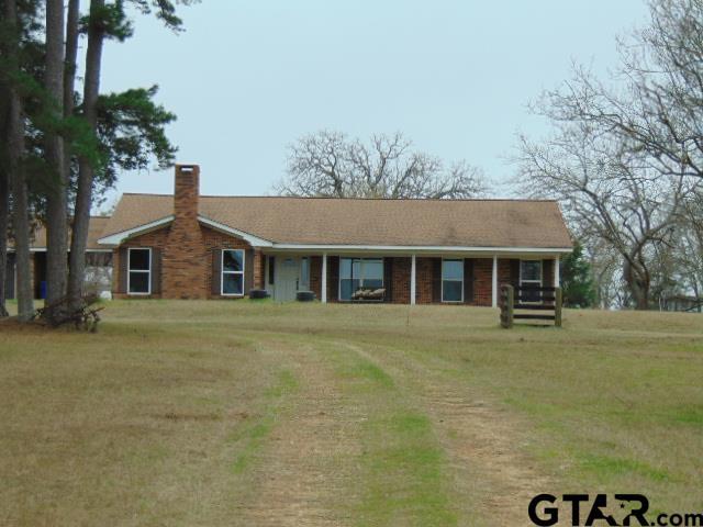 ranch-style house featuring a chimney and a front lawn