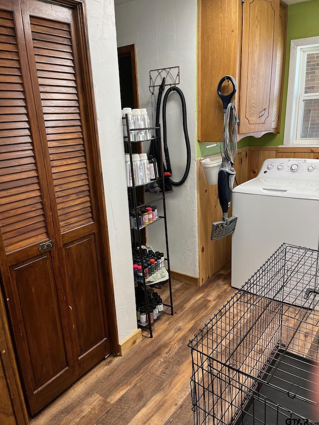 washroom with washer / clothes dryer, cabinet space, baseboards, and wood finished floors