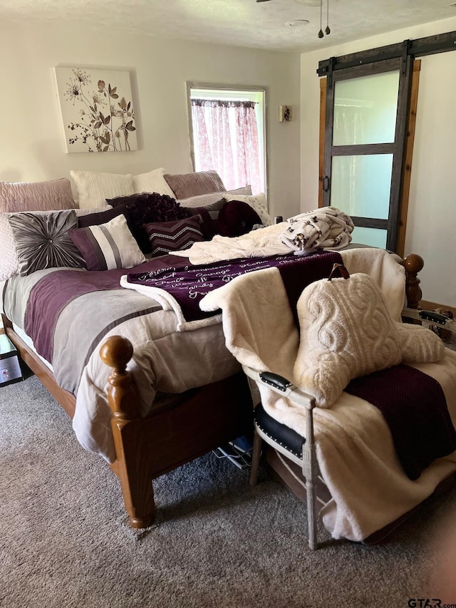 carpeted bedroom featuring a barn door