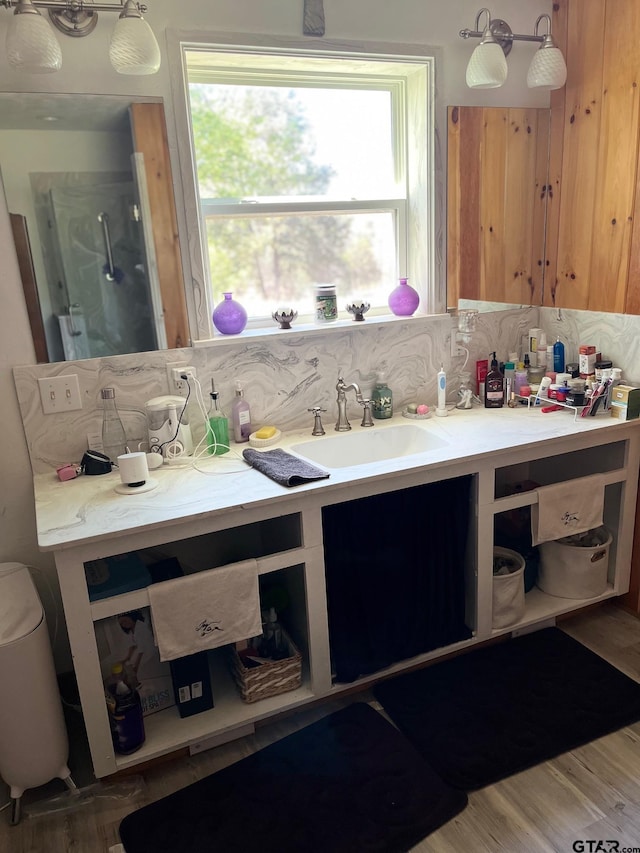 full bath with wood finished floors, walk in shower, backsplash, and vanity