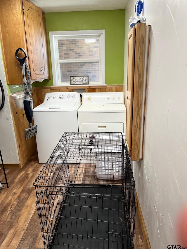 laundry room with cabinet space, wood finished floors, and washer and clothes dryer