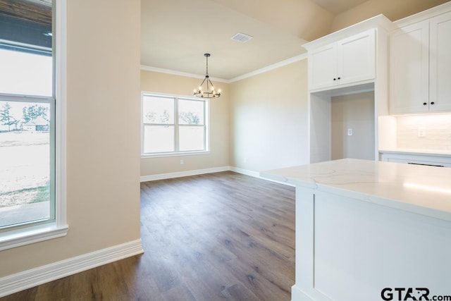 kitchen featuring light stone countertops, a wealth of natural light, an inviting chandelier, white cabinetry, and hanging light fixtures