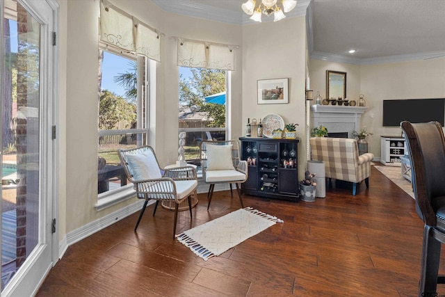 sitting room featuring dark hardwood / wood-style flooring, an inviting chandelier, and crown molding