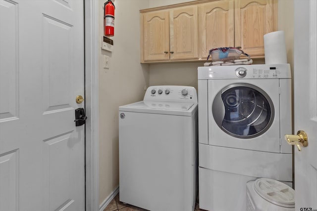 clothes washing area with cabinets, light tile patterned flooring, and separate washer and dryer