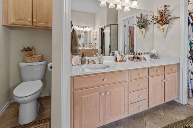 bathroom with toilet, vanity, and tile patterned floors