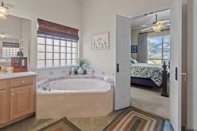 bathroom featuring vanity, a relaxing tiled tub, tile patterned floors, and ceiling fan