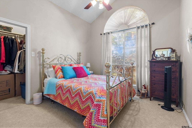 bedroom featuring light colored carpet, lofted ceiling, ceiling fan, and a closet