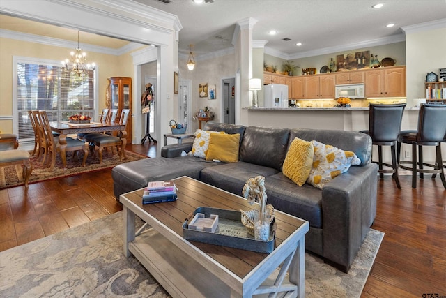 living room with ornamental molding, dark hardwood / wood-style floors, and a chandelier