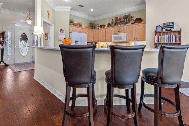 kitchen with ornamental molding, white appliances, dark hardwood / wood-style flooring, light brown cabinetry, and kitchen peninsula