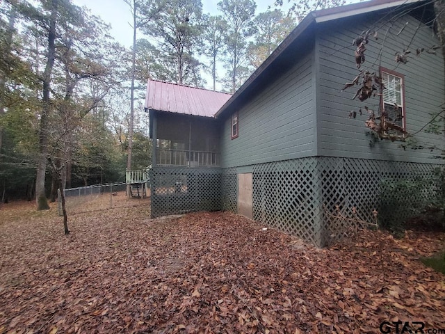 view of property exterior with a sunroom