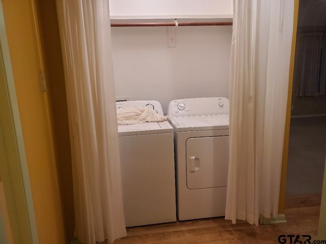 clothes washing area with independent washer and dryer and light hardwood / wood-style floors