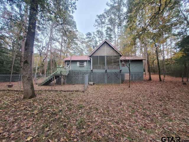 back of house with a wooden deck and a sunroom