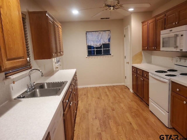 kitchen featuring light wood-type flooring, white appliances, ceiling fan, and sink