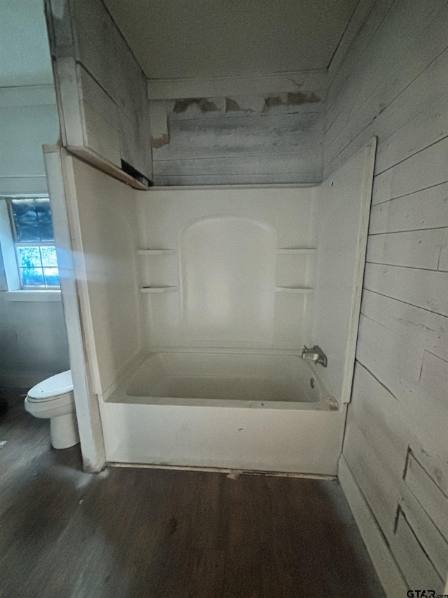 bathroom featuring hardwood / wood-style floors,  shower combination, and toilet