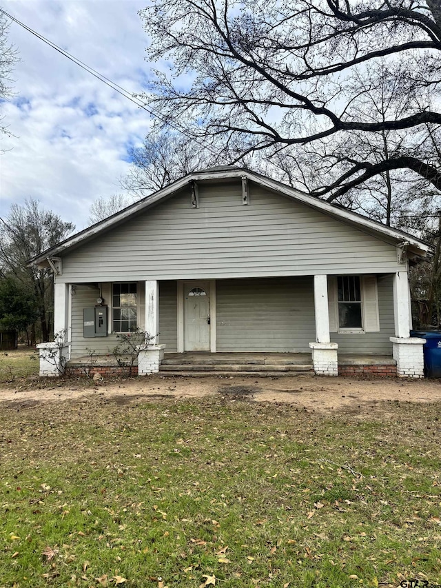 view of front of house featuring covered porch and a front yard