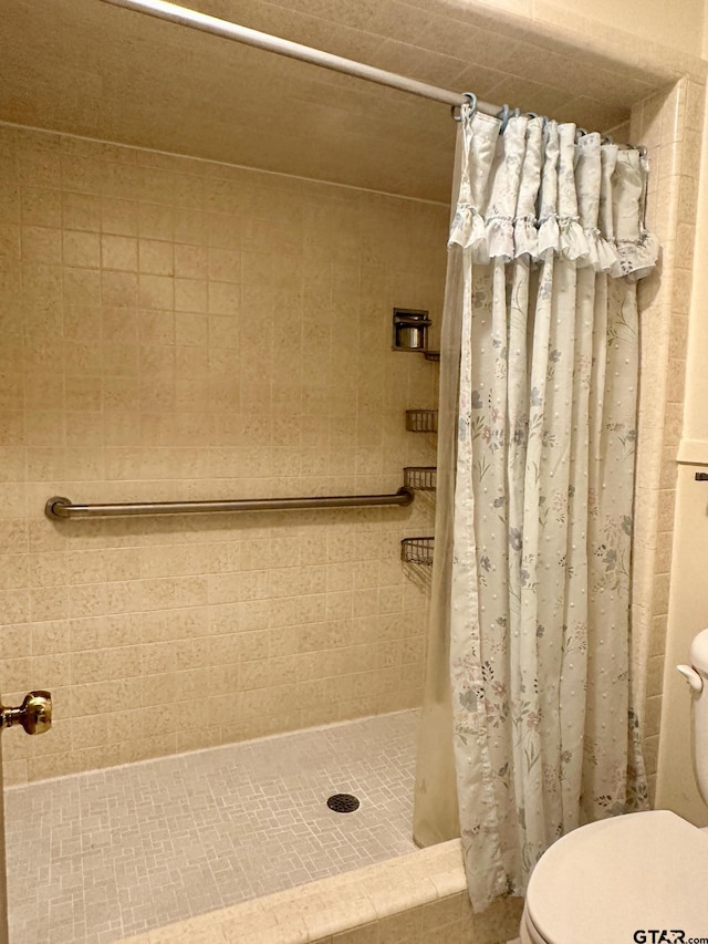 bathroom with curtained shower and toilet