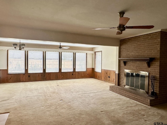 unfurnished living room with wooden walls, light carpet, and a brick fireplace