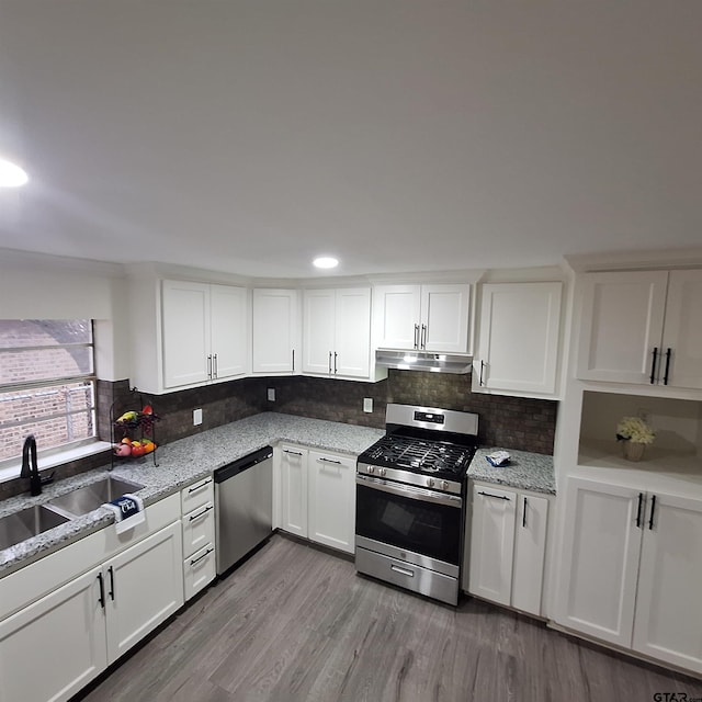 kitchen with sink, light hardwood / wood-style floors, white cabinets, and appliances with stainless steel finishes