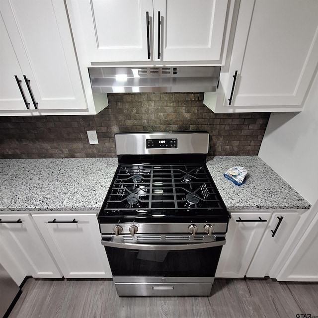 kitchen featuring hardwood / wood-style floors, backsplash, light stone counters, white cabinets, and stainless steel range with gas cooktop