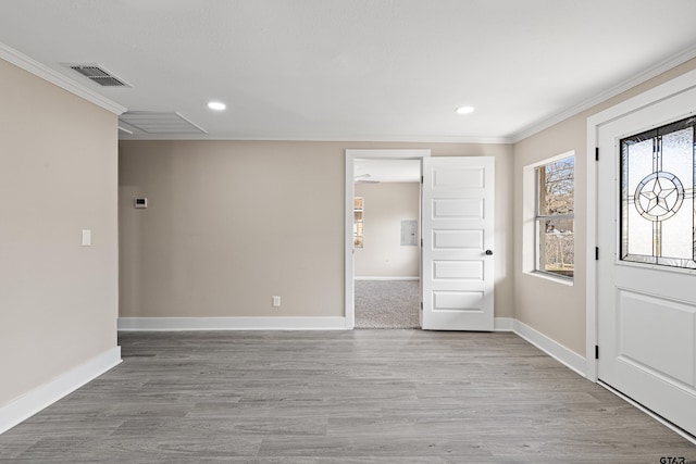 foyer featuring a healthy amount of sunlight, ornamental molding, and light hardwood / wood-style floors