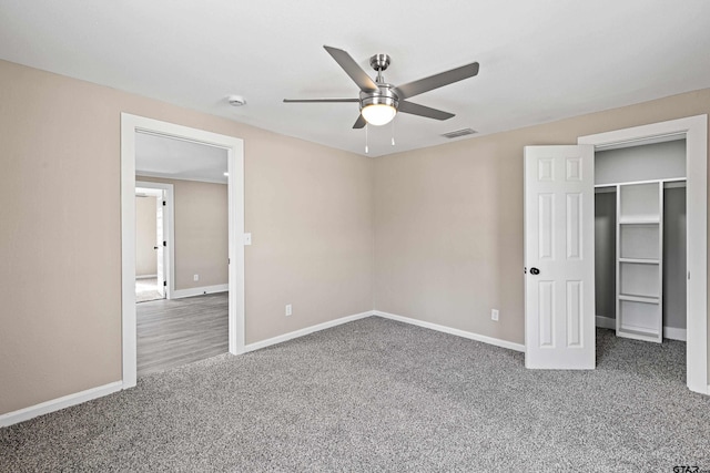 unfurnished bedroom with a walk in closet, ceiling fan, and carpet flooring