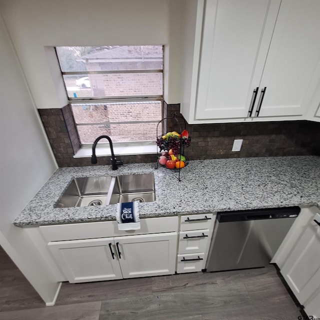 kitchen with sink, white cabinetry, light stone counters, dishwasher, and backsplash