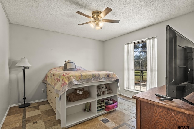 bedroom with ceiling fan and a textured ceiling