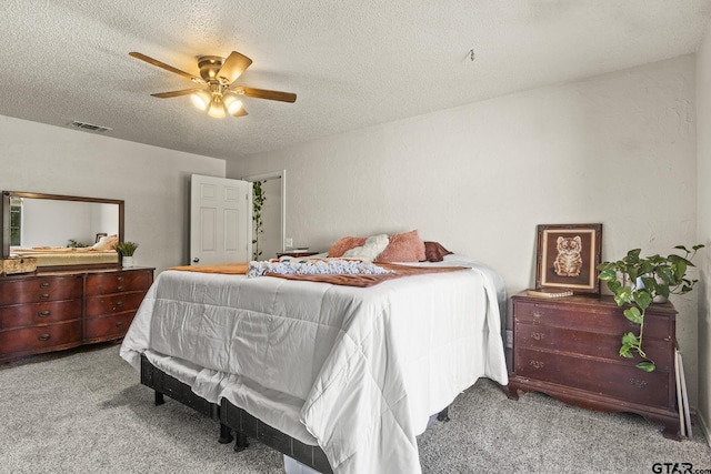 bedroom featuring ceiling fan, light carpet, and a textured ceiling