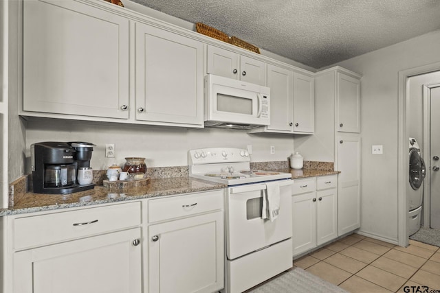 kitchen featuring light tile patterned floors, white appliances, white cabinets, and stone countertops