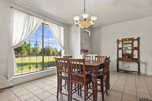 dining space featuring a chandelier, a textured ceiling, and light tile patterned floors