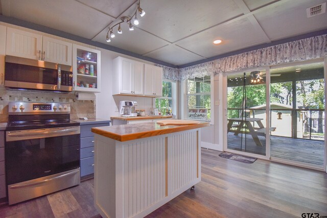 kitchen featuring a center island, dark wood-type flooring, stainless steel appliances, decorative backsplash, and white cabinets