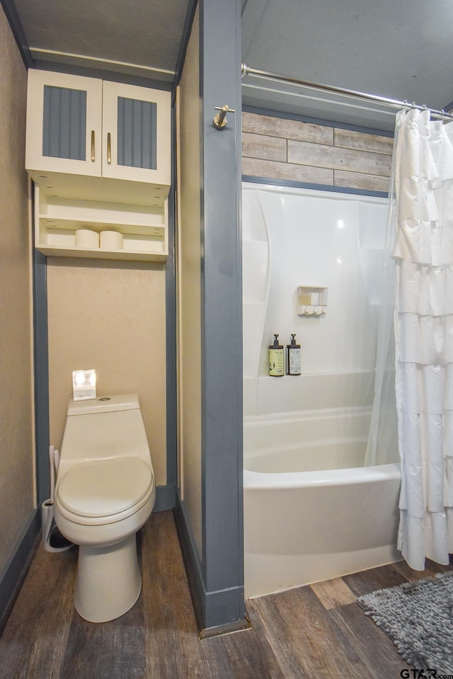 bathroom with hardwood / wood-style floors, shower / bath combination with curtain, and toilet