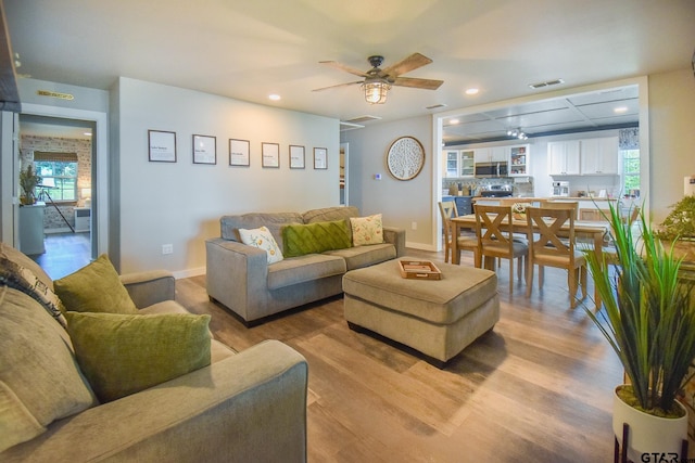 living room with light hardwood / wood-style flooring and ceiling fan