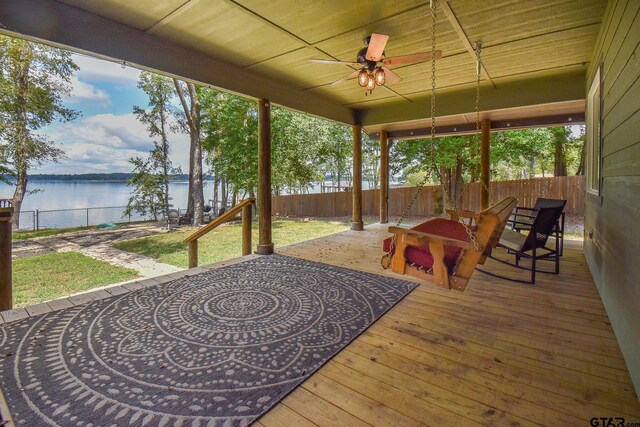 sunroom with ceiling fan, a water view, and a wealth of natural light