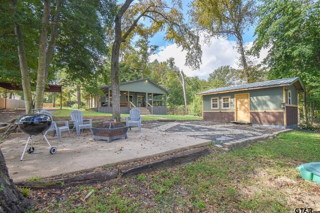 back of property featuring a fire pit and a patio area