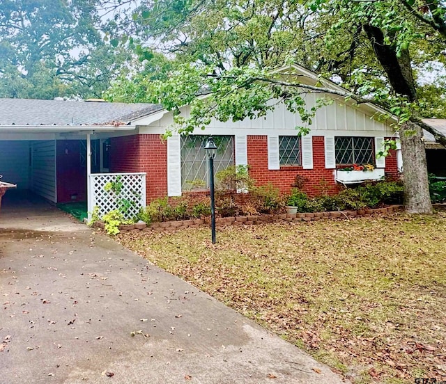 view of side of property featuring a lawn and a carport