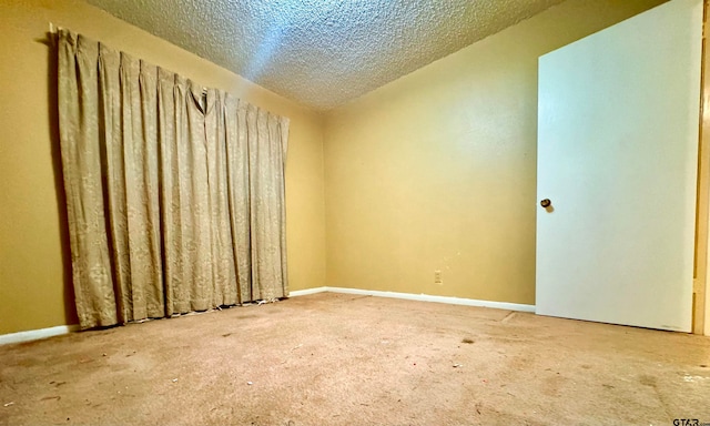 carpeted empty room with a textured ceiling and lofted ceiling