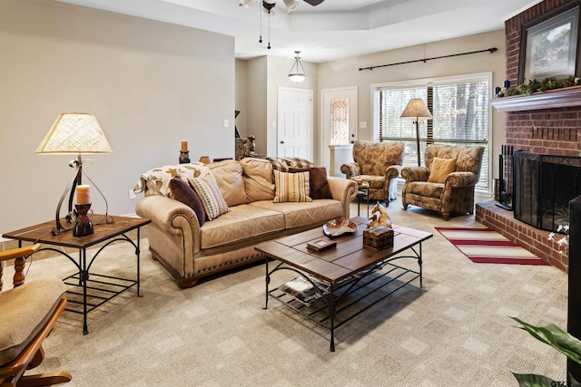 living room featuring light carpet, a fireplace, and a ceiling fan