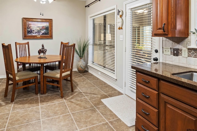 tiled dining room featuring baseboards