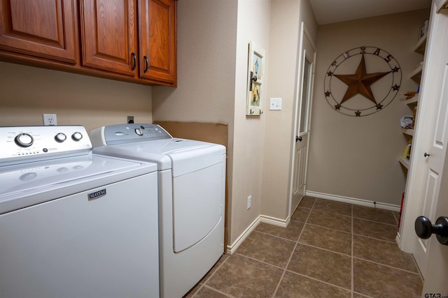 laundry room featuring cabinet space, washer and dryer, baseboards, and dark tile patterned flooring