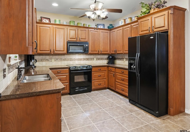 kitchen featuring tasteful backsplash, brown cabinetry, black appliances, a ceiling fan, and a sink