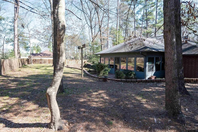 view of yard with fence and a sunroom