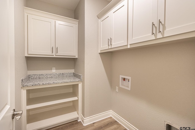 laundry area with cabinets, hookup for a washing machine, and hardwood / wood-style floors