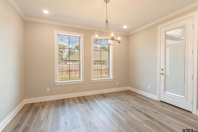 unfurnished dining area featuring light hardwood / wood-style flooring, ornamental molding, and a chandelier