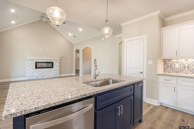 kitchen with sink, light hardwood / wood-style flooring, an island with sink, white cabinets, and stainless steel dishwasher