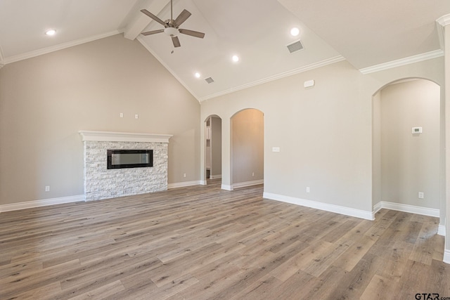 unfurnished living room featuring high vaulted ceiling, a stone fireplace, light hardwood / wood-style floors, and ceiling fan