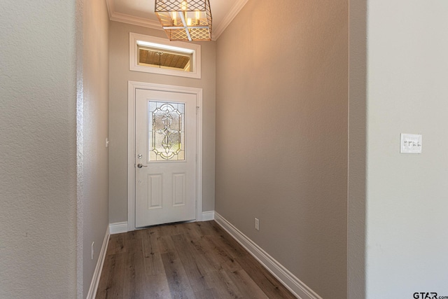 doorway featuring crown molding, dark hardwood / wood-style floors, and a chandelier