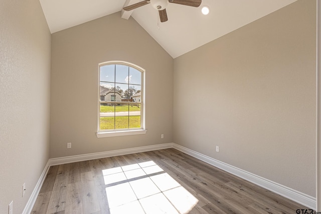 unfurnished room featuring ceiling fan, light hardwood / wood-style floors, and vaulted ceiling with beams