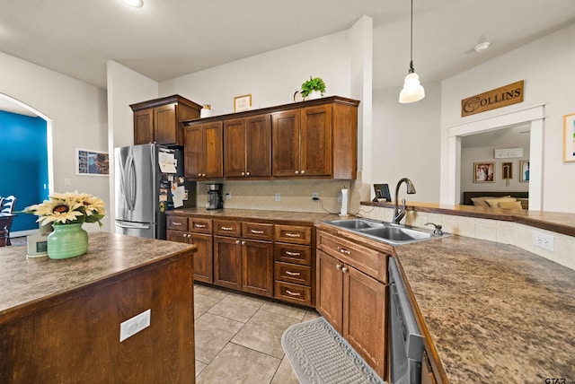 10926 Westhaven Cir, Flint, TX 75762 - kitchen with appliances with stainless steel finishes, light tile patterned flooring, pendant lighting, arched walkways, and dark countertops