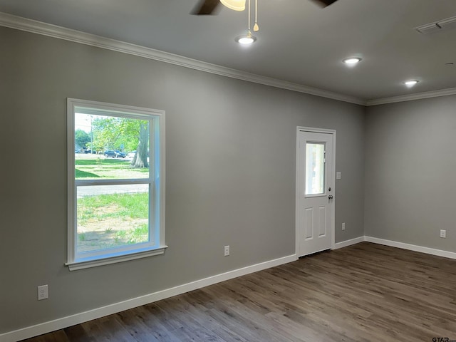 unfurnished room featuring dark wood-type flooring, a healthy amount of sunlight, ceiling fan, and crown molding